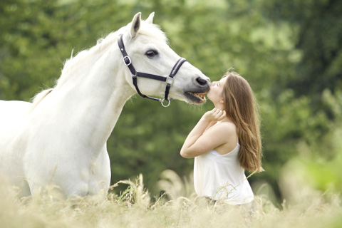 Mädchen gibt Pferd küsschen